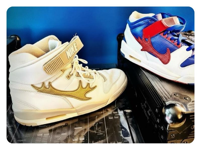 Two Nike Air Revolution shoes with custom moose antlers as swooshes sitting on DJ equipment